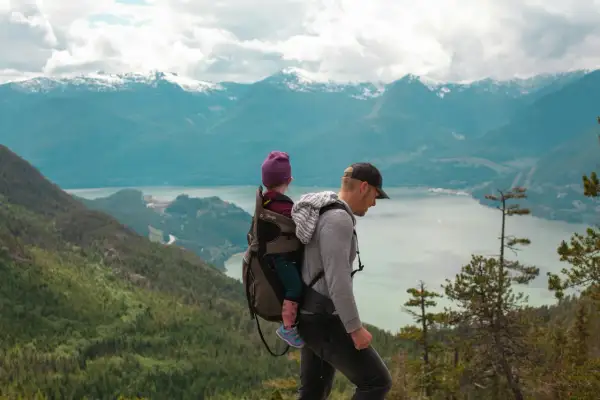 Ojciec z dzieckiem w nosidle na tle gór. Gdzie w Tatry? To pytanie zadaje sobie wielu, ale ten widok zapiera dech w piersiach.